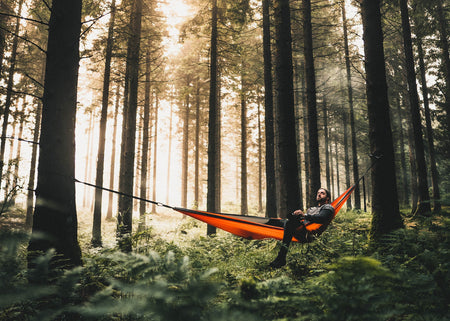 Man in Sunburnt Orange Recycled Double Hammock in forest