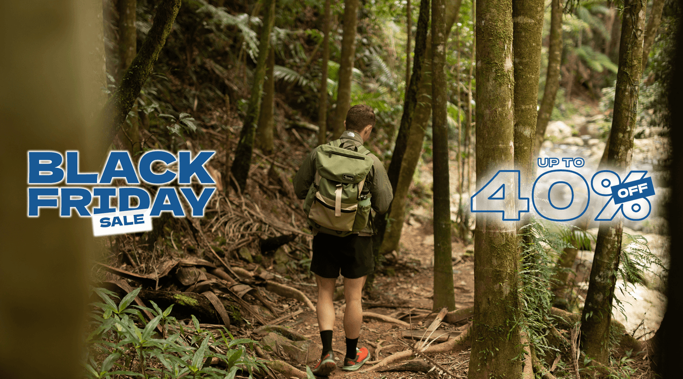 Man hiking in forest with sustainable Nakie backpack made from recycled plastic bottles, ideal eco-friendly hiking gear