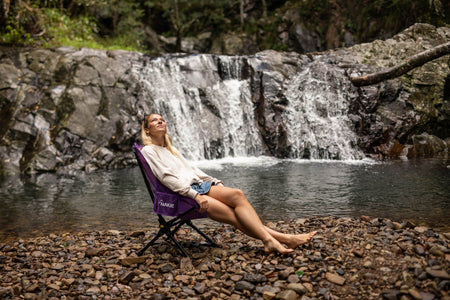 Mulberry Purple camping chair in front of a waterfall