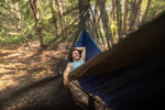 A smiling man lying comfortably in a Nakie hammock, with the Bug Net draped over, showcasing its effectiveness in providing insect protection for a blissful outdoor experience. preview #4