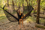 A woman sitting on a hammock in a campsite, zipping down Nakie's Bug Net, preparing for a comfortable and insect-free outdoor experience. preview #11