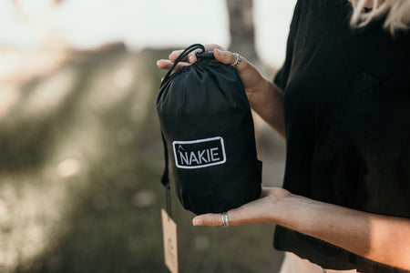 A woman holding an unopened Nakie Bug Net, showcasing its compact and portable design for easy outdoor use.