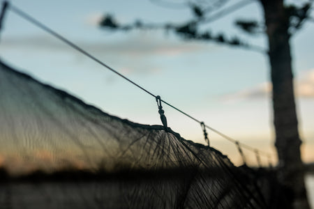 Close-up of guylines securely attached to Nakie's Bug Net, illustrating the stability and easy setup of the outdoor protection system.