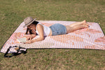 Woman wearing a hat, basking in the sun on a Nakie picnic blanket, capturing the essence of outdoor relaxation and leisure. preview #7